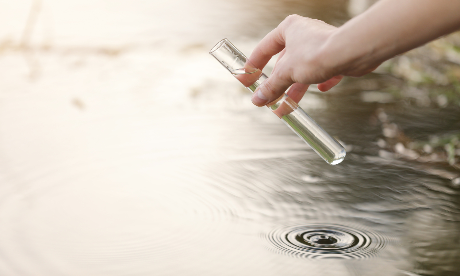 tubo de ensaio coletando agua com residos de um tanque